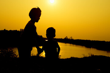 Silhouette of a family comprising a father, mother and two children happy family the sunset.Concept of friendly  - 646230057