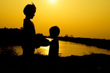 Silhouette of a family comprising a father, mother and two children happy family the sunset.Concept of friendly  - 646230060