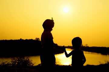 Silhouette of a family comprising a father, mother and two children happy family the sunset.Concept of friendly  - 646230068