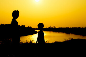 Silhouette of a family comprising a father, mother and two children happy family the sunset.Concept of friendly  - 646230091