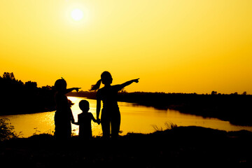 Silhouette of a family comprising a father, mother and two children happy family the sunset.Concept of friendly  - 646230250