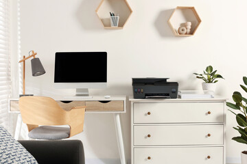 Stylish workplace with modern computer, printer and lamp