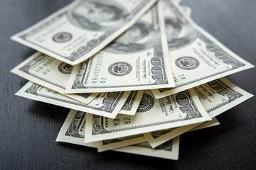 american hundred dollar bills banknotes lies on black desk
