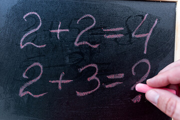 close up hand write primary simple mathematical equation. Math chalkboard