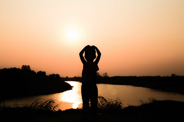 Silhouette of a family comprising a father, mother and two children happy family the sunset.Concept of friendly 