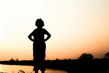 Silhouette of a family comprising a father, mother and two children happy family the sunset.Concept of friendly 