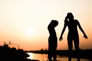 Silhouette of a family comprising a father, mother and two children happy family the sunset.Concept of friendly  - 646231609