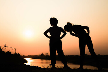 Silhouette of a family comprising a father, mother and two children happy family the sunset.Concept of friendly  - 646231682