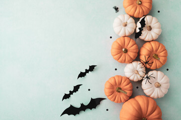 Orange pumpkins, spiders and bats on blue table top view. Happy halloween greeting card.