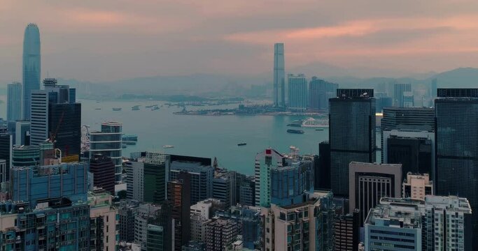 Aerial panning shot of Wan Chai district under low clouds during sunrise. Hong Kong Island