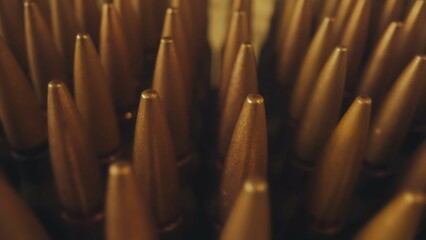 Rows of numerous rifle cartridges close up. The concept of firearms, shooting range, production and...
