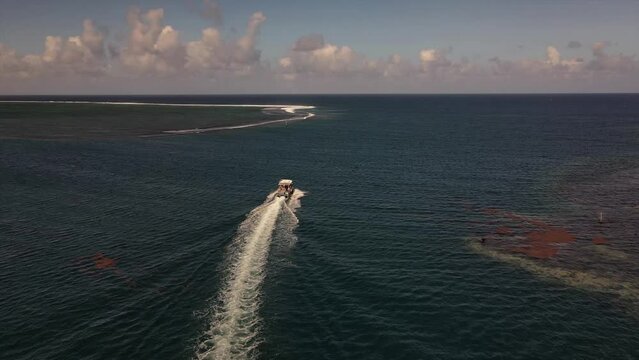 Speed boat heading out to sea through a channel between two reefs in Teahupoo Tahiti