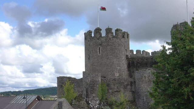 A majestic large stone castle  towers over the medieval village of Conwy Wales