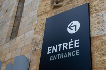 sign indicating entree panel in french text means entrance signage with white arrow