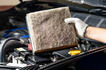 Poster Repair and check car air conditioning system Technician holds car air filter to check cleanliness Clogging dirty or replacing the filter. Engine and transportation industry © WIROT