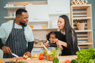 Kind African american parents teaching their adorable daughter how to cook healthy food, free space of kitchen, Happy black people family preparing healthy food in kitchen together