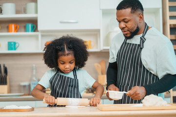 Kind African american parents teaching their adorable daughter how to cook healthy food, free space of kitchen, Happy black people family preparing healthy food in kitchen together