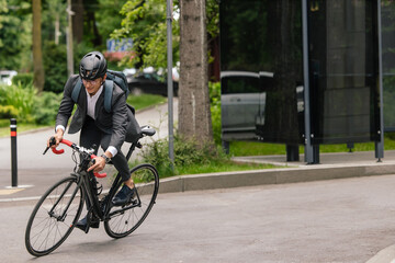 Obraz na płótnie Canvas Man in protective hemlet riding a bike on the road