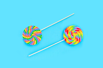 Rainbow lollipop on blue background.