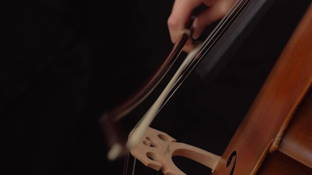 close up of woman playing staccato on the cello