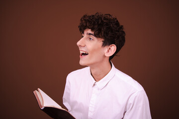 Funny student posing on a brown background early in the morning.