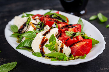 Caprese salad tomato for concept design. Dark background, close up. Food concept.