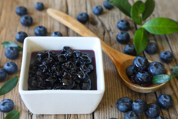 Blueberry jam in jar with berries and leaves