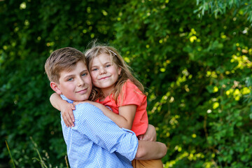 Happy Little Girl Embraces Her Loving Brother, Teenager Boy, Showcasing the Warmth and Love within Their Family Bond. Carefree Childhood, Brother and Sister Bonding.