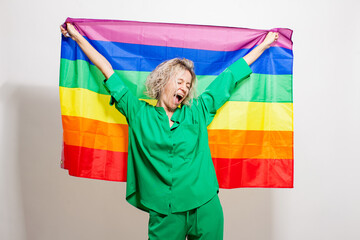 Middle aged woman smiling posing with rainbow LGBT flag