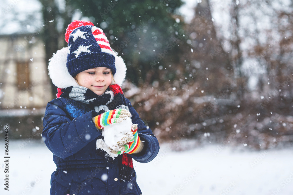 Wall mural Cute little preschool girl outdoors in winter park . Adorable healthy happy child playing and having fun with snow, outdoors on cold day. Active leisure with children in winter