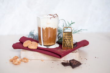Still life with a cup of coffee latte, cookies and cade branch in Christmas mood. Small gold grater for chocolate. Copy Space