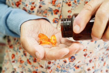 Asian elderly woman holding pill drug in hand, strong healthy medical concept.