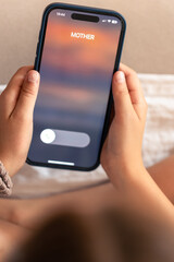 Smartphone in child hands with Incoming mother call on a screen.