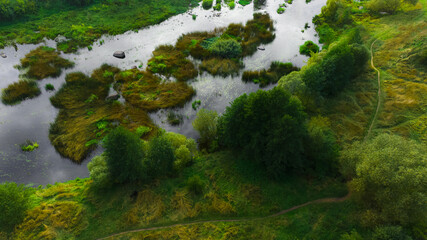 aerial top point view of idyllic country side landscape summer warm morning pond shore line parkland environment space with tees and grass