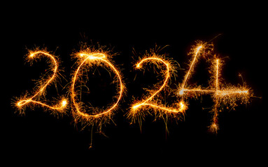 Jahreszahlen 2023 mit Wunderkerzen geschrieben vor dunklem Hintergrund.	