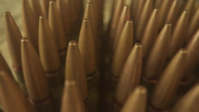 Rows of numerous rifle cartridges close up. The concept of firearms, shooting range, production and trade of ammunition.
