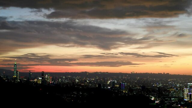 Fantasy orange sky. The vibrant and bustling night scene of Taipei City. Night view of the city surrounded by mountains is hazy and dreamy. Dajianshan, Taiwan
