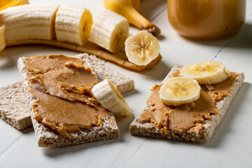 Diet breads with peanut butter and pieces of banana. A healthy snack.