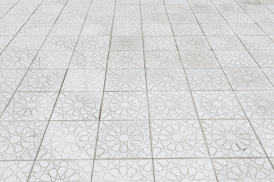 The texture of a monotonous tiled pavement with perspective. Abstract background.