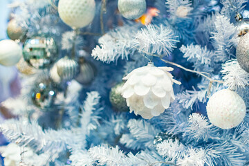 Fototapeta na wymiar Close up of Christmas tree with white ornaments.