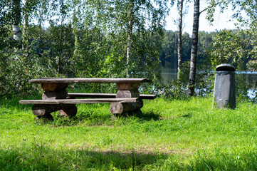 wooden bench and table near forest trail