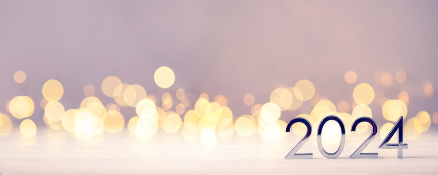 Metal Numbers 2024 On A White Table With Christmas Trees And Bokeh Lights. Happy New Year 2024 Is Coming Concept.