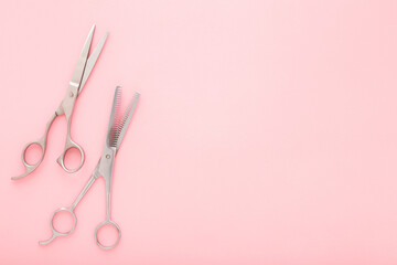 New professional hair scissors and thinning shears on light pink table background. Pastel color. Closeup. Top down view. Empty place for text. - obrazy, fototapety, plakaty