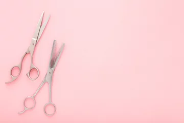 Fototapete Schönheitssalon New professional hair scissors and thinning shears on light pink table background. Pastel color. Closeup. Top down view. Empty place for text.