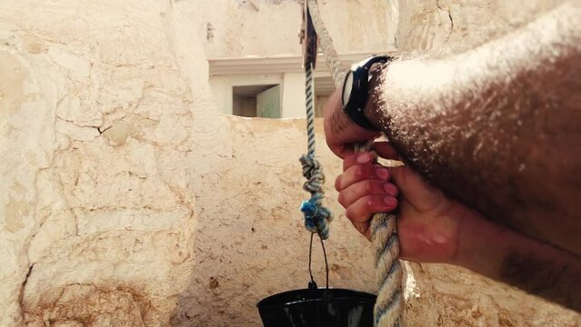 a man pulls on the rope to remove the seal from the well