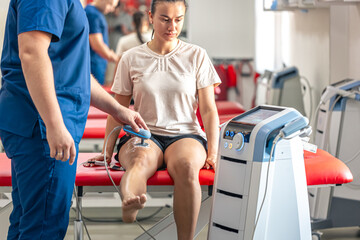 Doctor using machine to treat the knee joints of a patient.