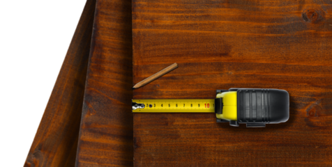 Close-up of a yellow and black tape measure and a pencil on wooden boards, isolated on white or transparent background with copy space. Png.