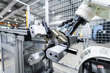 White robotic arm with machinery in factory