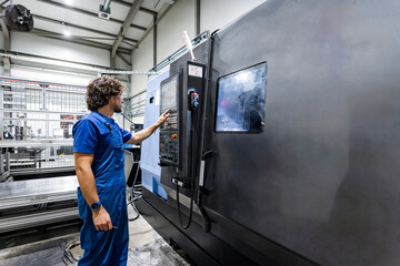 Technician operating metal machinery in industry