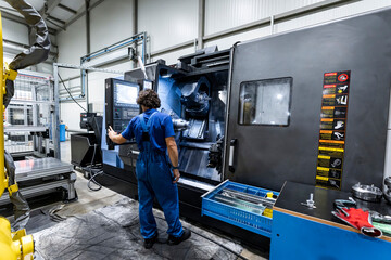 Technician operating cnc machinery in metal industry